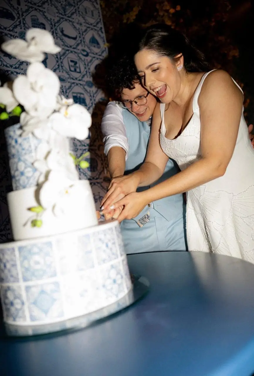 Momento do corte do bolo de casamento com azulejo português e orquídeas da Alegra Cakes em Florianópolis