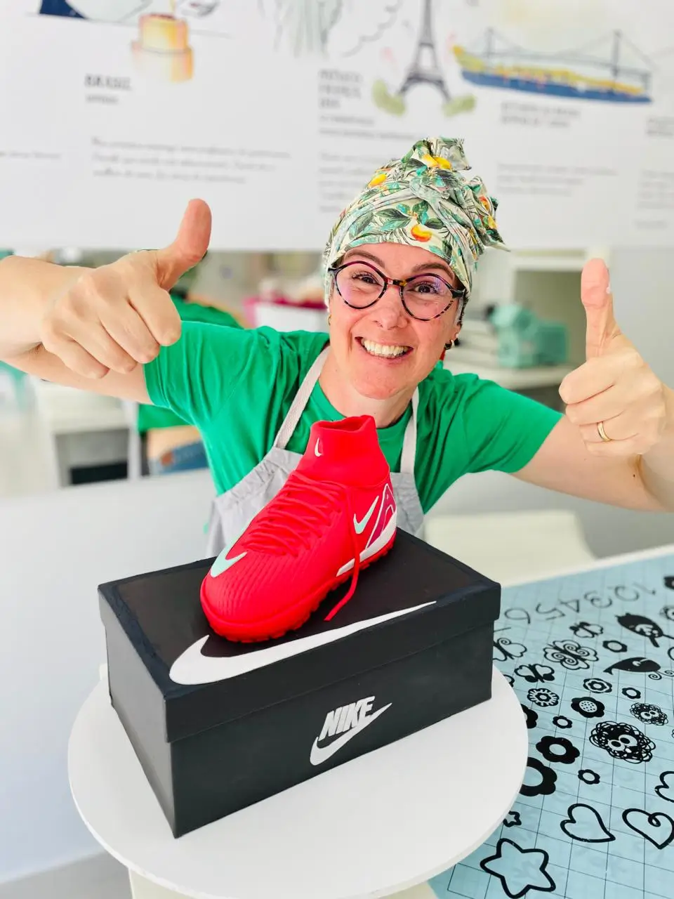 Confeiteira apresentando bolo personalizado em formato de chuteira de futebol da Alegra Cakes em Florianópolis