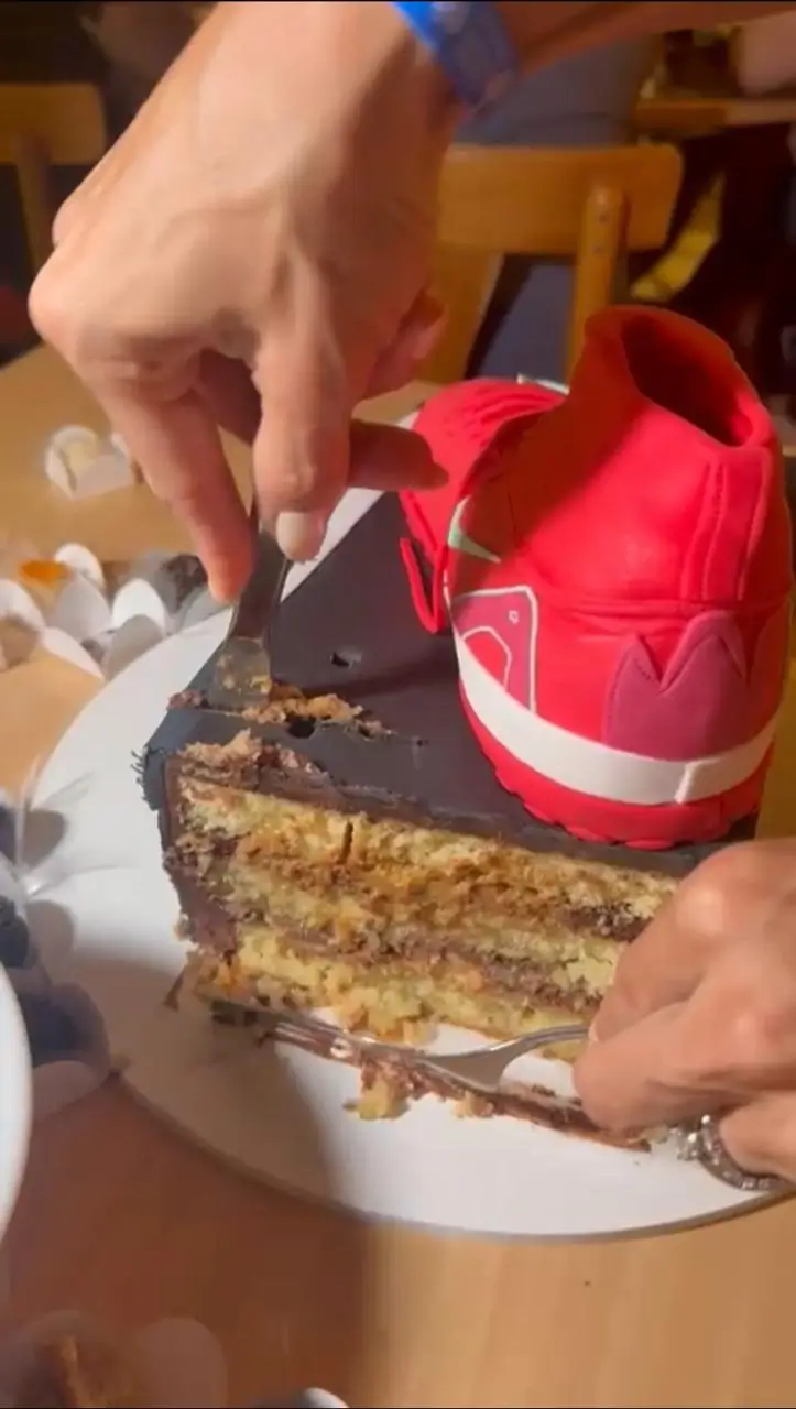 Fatia de bolo de aniversário tema futebol com recheio e decoração de chuteira da Alegra Cakes em Florianópolis