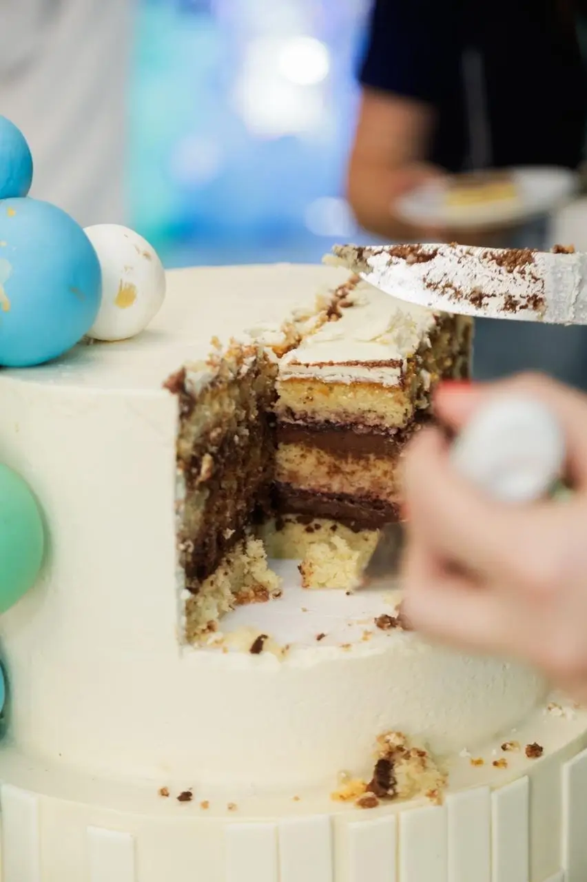 Fatia de bolo corporativo mostrando recheio e camadas em evento de empresa da Alegra Cakes em Florianópolis