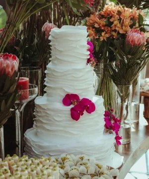 Bolo de casamento elegante com decoração floral e orquídeas em mesa decorada da Alegra Cakes em Florianópolis